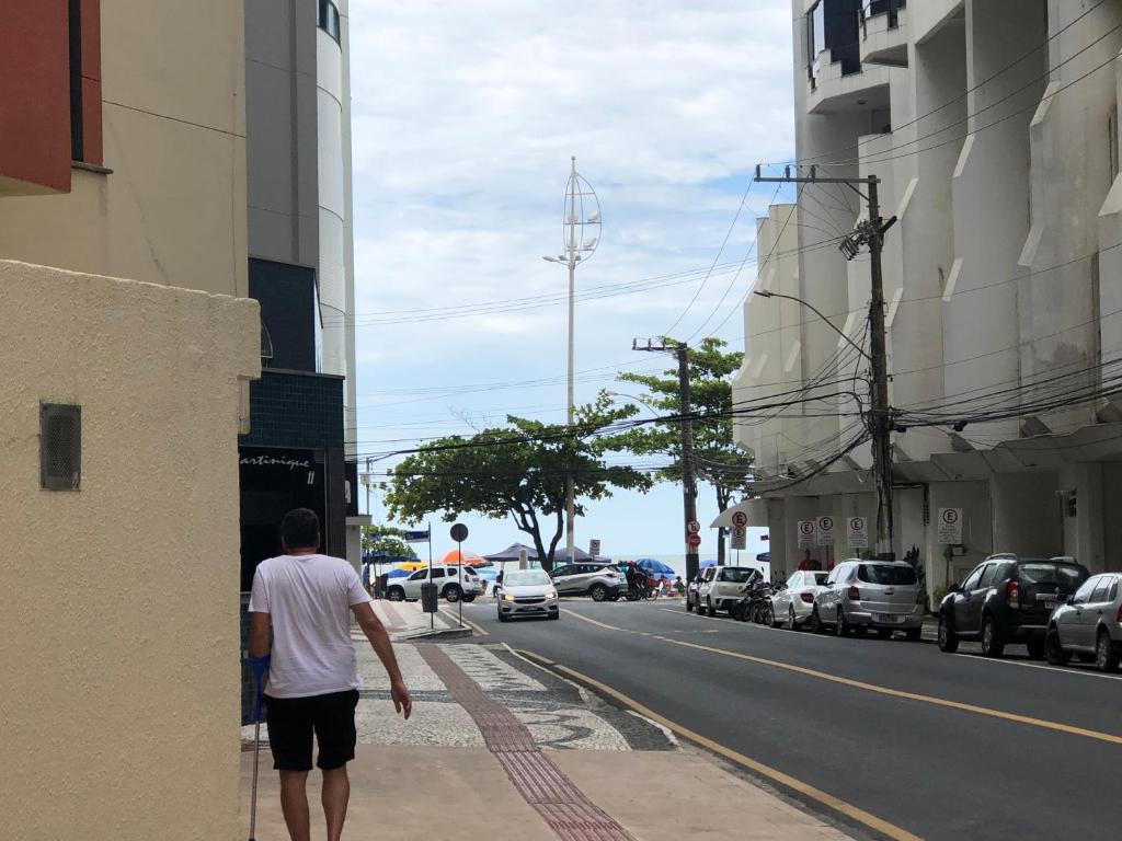 un hombre caminando por una acera en una calle de la ciudad en Apartamento 30 Mts Praia Balneário Camboriú, en Balneário Camboriú