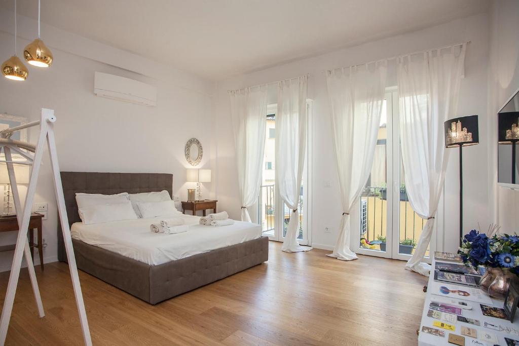 Habitación blanca con cama y balcón. en LoveTheStylish OldBridge - LoveTheApartments, en Florencia