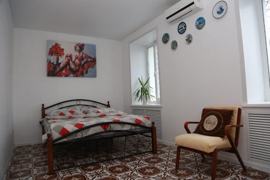 1 dormitorio con 1 cama y 1 silla en VIB Apartment near station en Vitebsk