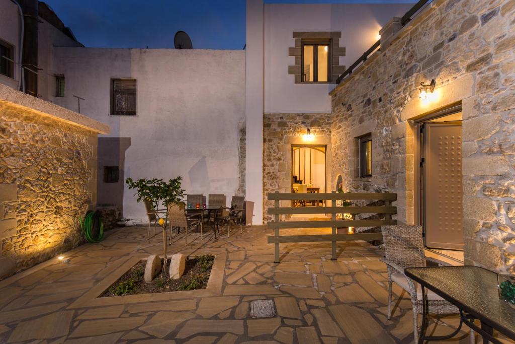 een patio met een tafel en stoelen en een gebouw bij Agarathos Deluxe Homes in Kissamos