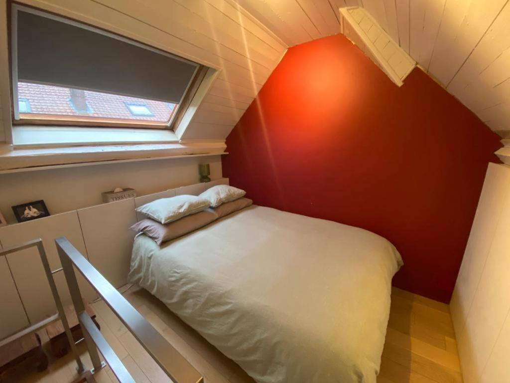 een kleine kamer met een bed in een kamer met een raam bij B&B Riverside - Centre of Bruges in calm area in Brugge