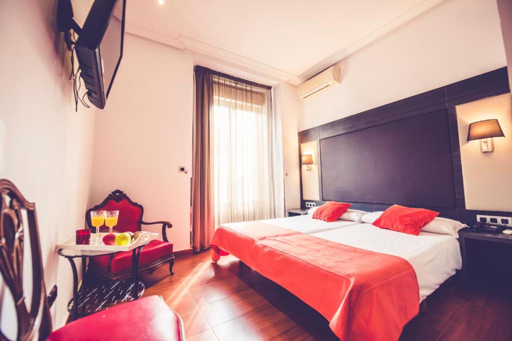 una camera d'albergo con un grande letto e un tavolo di Hostal Sol Los Angeles a Madrid