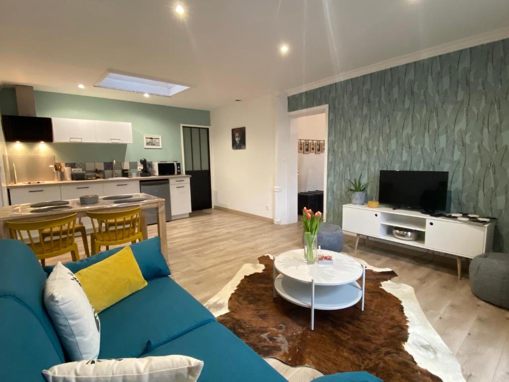 a living room with a blue couch and a table at Maison de ville de 55m2 refait à neuf in Verneuil d'Avre et d'Iton