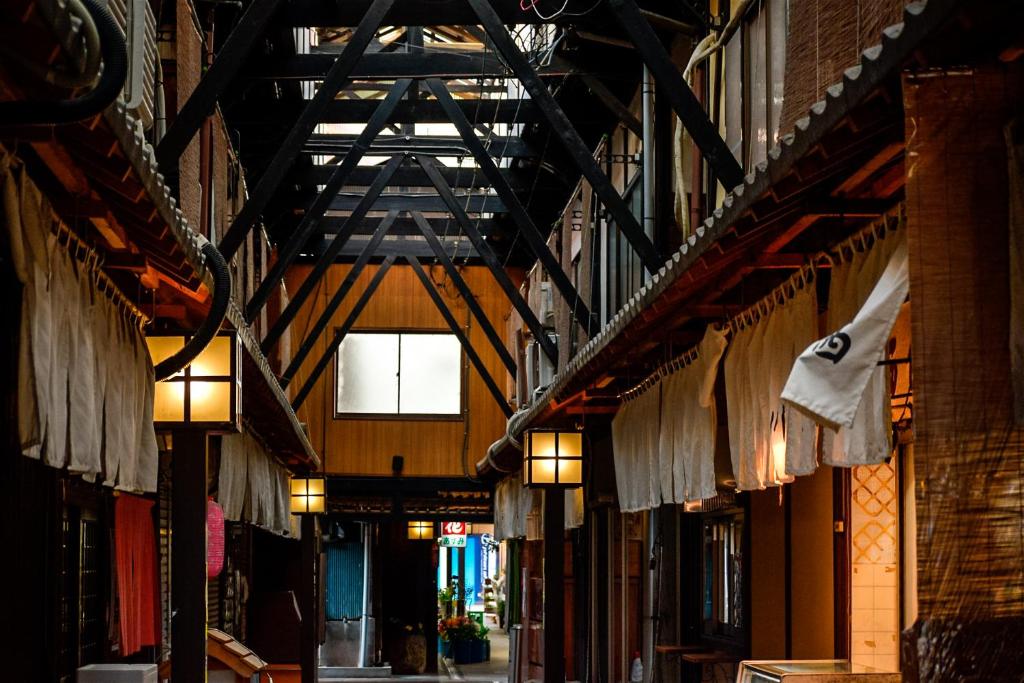 an alley with clothes hanging from the ceilings of a building at Toyooka guesthouse Hostel Act in Toyooka