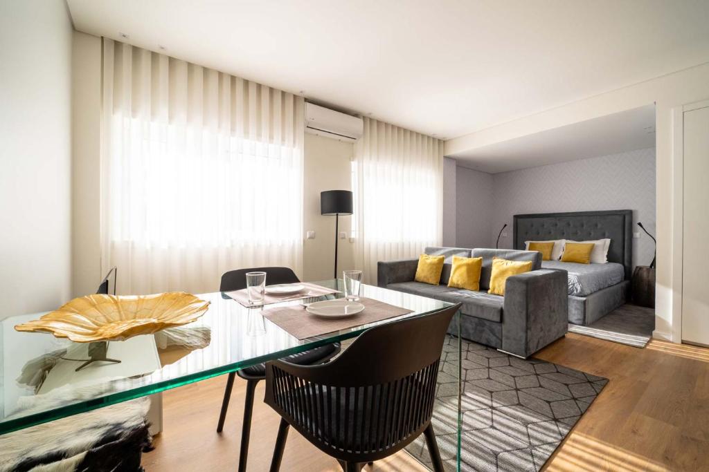 uma sala de estar com uma mesa e um sofá em Bracara Guest House "Campo das Hortas" em Braga