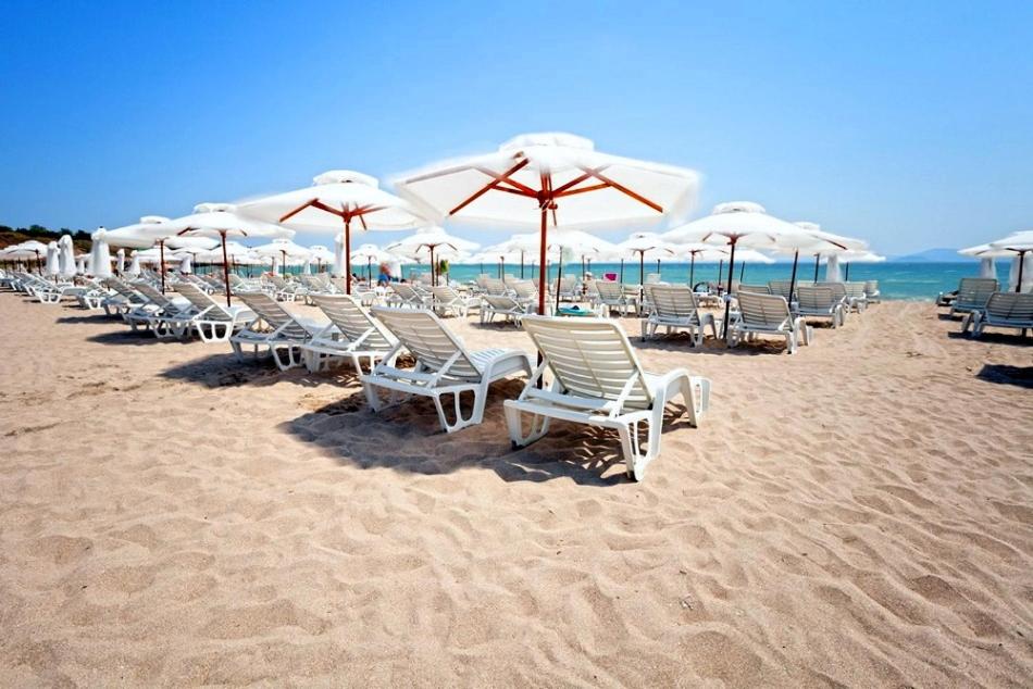 a row of chairs and umbrellas on a beach at Sunny Apartment relax & spa in Burgas City