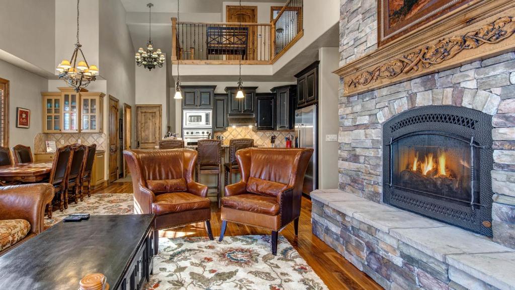 a living room with a stone fireplace and leather chairs at Stillwater Shores 1273 in Heber City