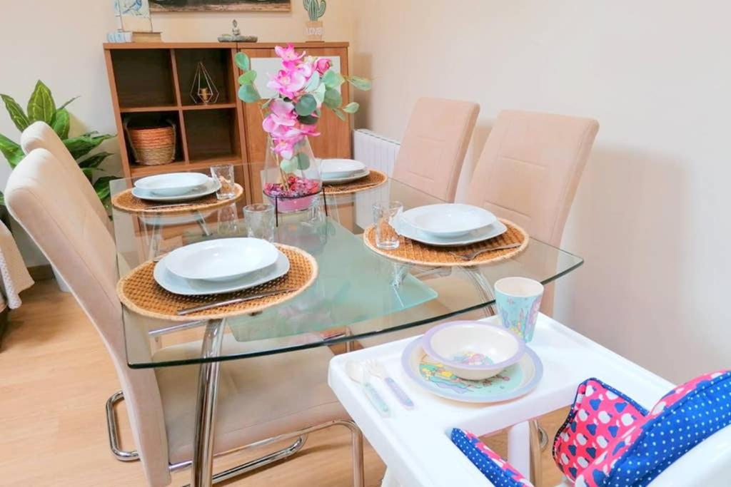 uma mesa de vidro com cadeiras e pratos em Bajo las estrellas em Lugo