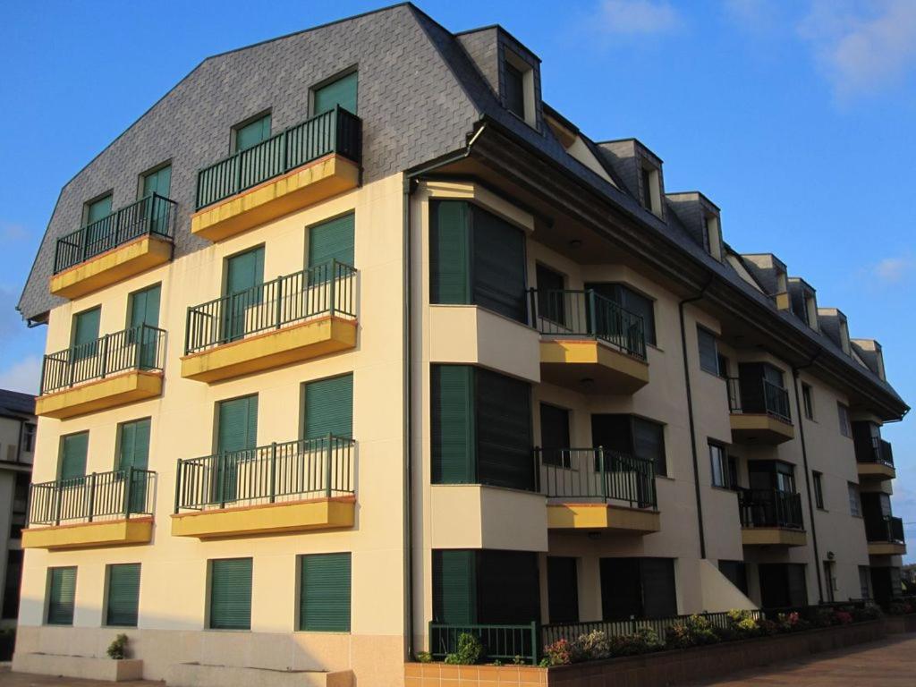 a building with balconies on the side of it at Apartamento Playa Catedrales in Barreiros