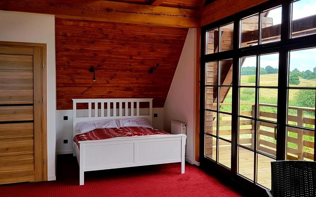 A bed or beds in a room at Karczma Tyrolska u Martina