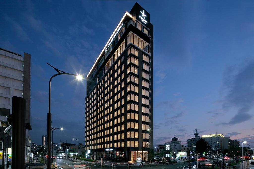 a tall building with a clock on top of it at Candeo Hotels Omiya in Saitama
