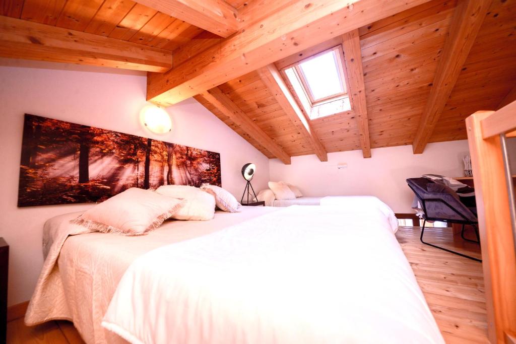 Un dormitorio con una cama blanca en una habitación con techos de madera. en Walk 2 Town, en Arco