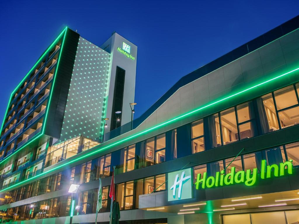 a building with a holiday inn sign in front of it at Holiday Inn Antalya - Lara by IHG in Antalya