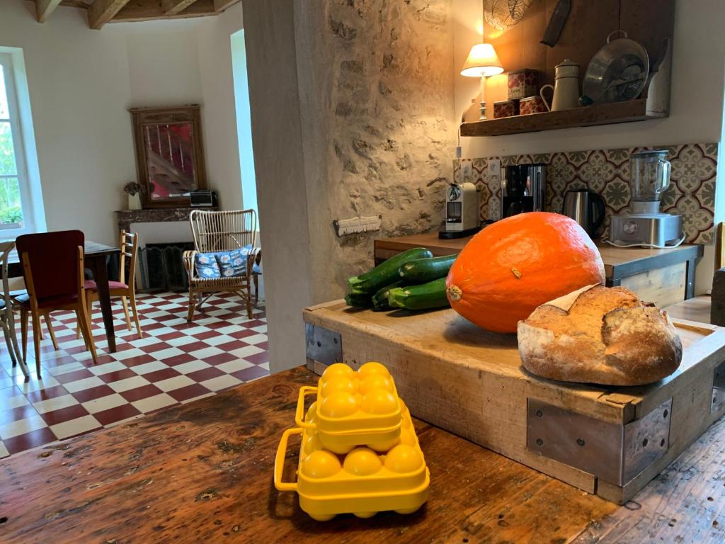 a kitchen with a table with a pumpkin and bread on it at La Motte in Louroux-de-Bouble