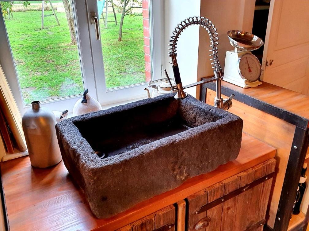 an old stone sink in a kitchen with a window at La Motte in Louroux-de-Bouble