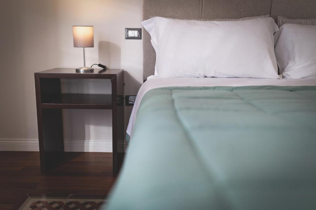 a bedroom with a bed and a night stand with a lamp at Piazza Duomo Deluxe in Cecina