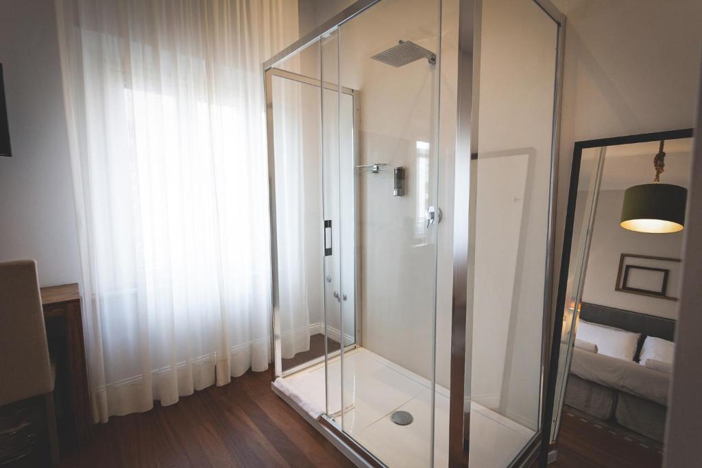 a glass shower in a room with a window at Piazza Duomo Deluxe in Cecina