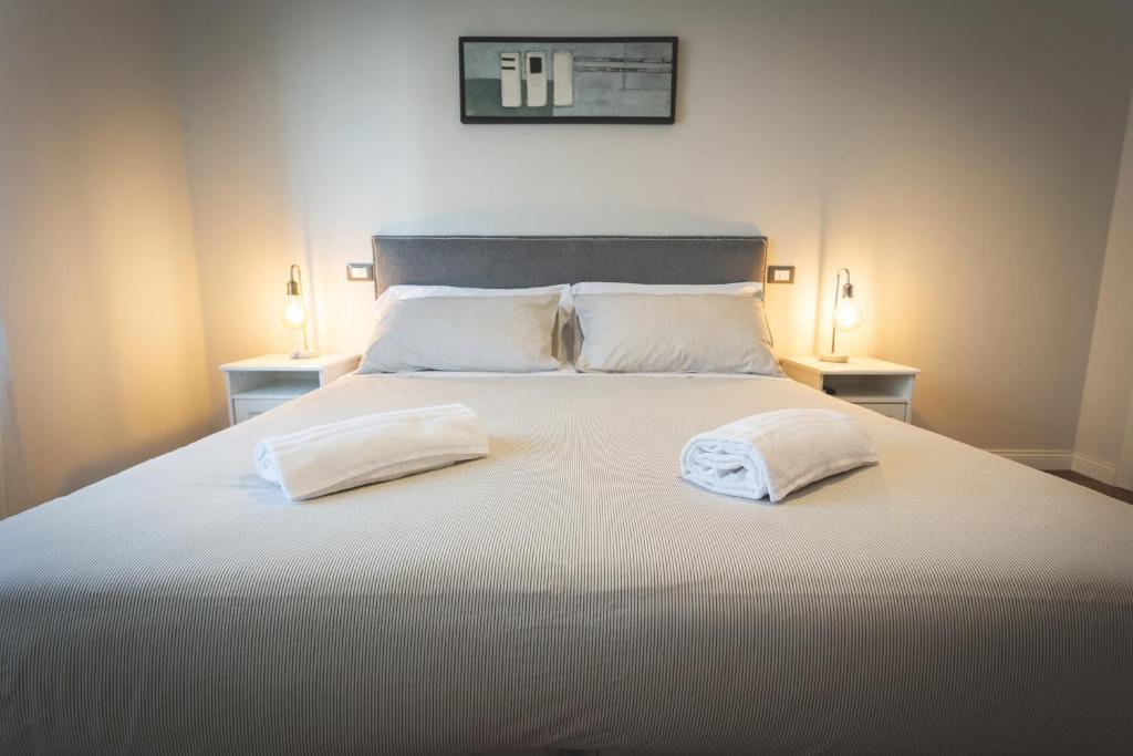 a bedroom with a large bed with two pillows at Piazza Duomo Deluxe in Cecina