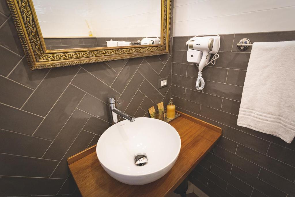 a bathroom with a white sink and a mirror at Piazza Duomo Deluxe in Cecina