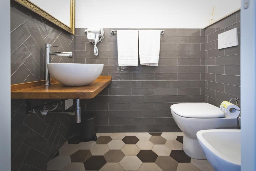 a bathroom with a sink and a toilet at Piazza Duomo Deluxe in Cecina