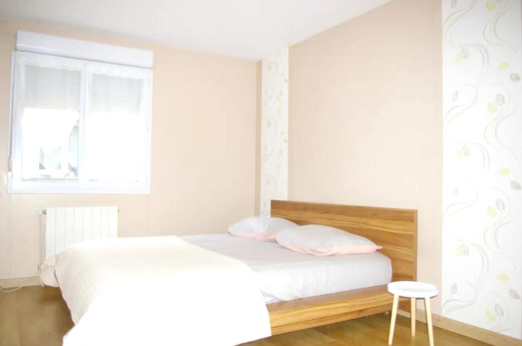 a bedroom with a bed and a window and a stool at Maison de 4 chambres avec jardin clos et wifi a Chenove in Chenôve