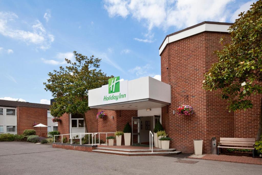 a building with a sign on the front of it at Holiday Inn Basingstoke by IHG in Basingstoke