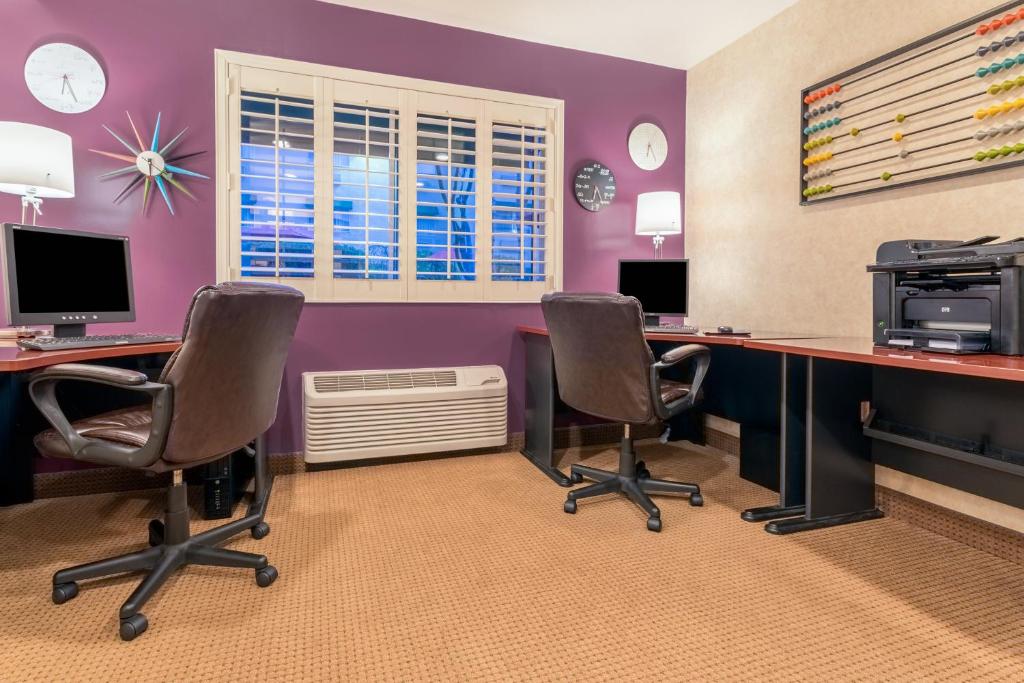 une chambre avec 2 bureaux avec des chaises et un ordinateur dans l'établissement Holiday Inn Auburn, an IHG Hotel, à Auburn