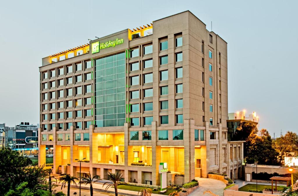 un bâtiment d'hôtel avec un panneau sur celui-ci dans l'établissement Holiday Inn Amritsar Ranjit Avenue, an IHG Hotel, à Amritsar