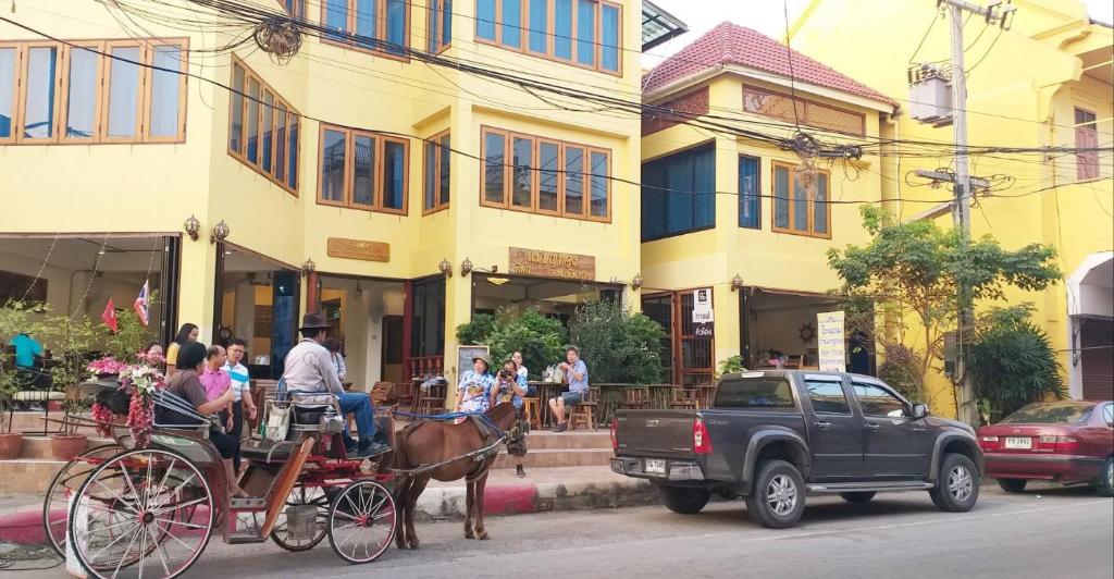 a horse drawn carriage on a street in front of a building at Ban Mae Boonthong in Lampang