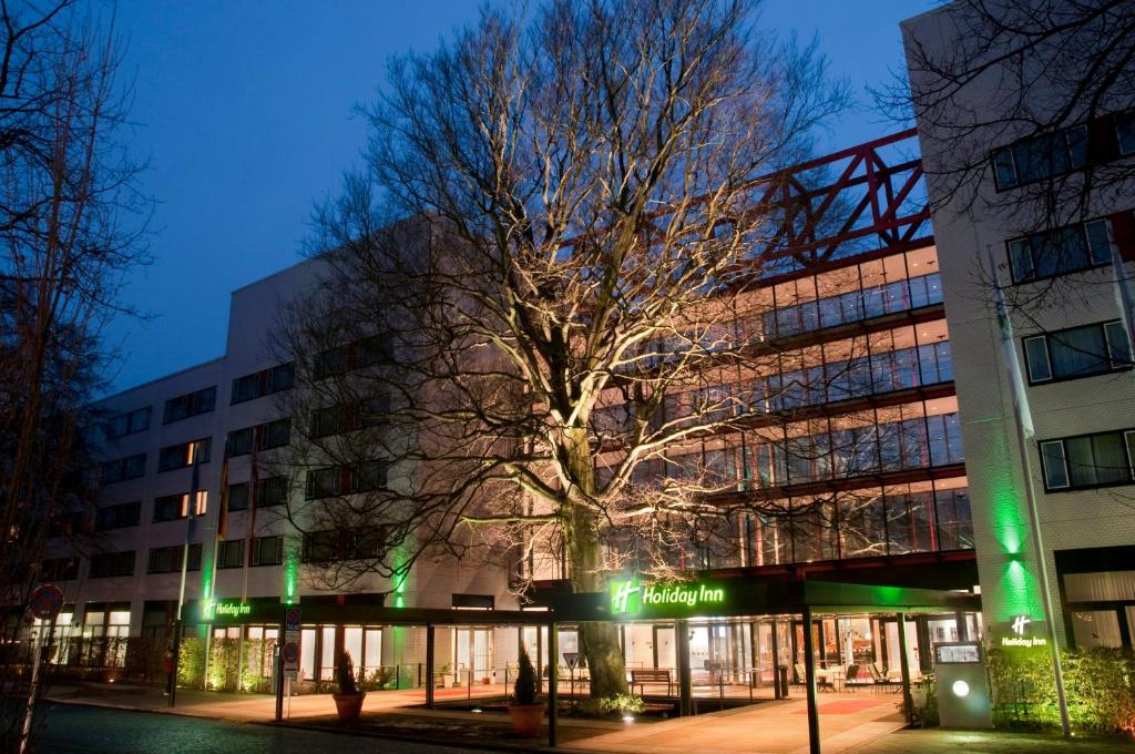 un edificio con un árbol delante de él en Holiday Inn Berlin City-West, an IHG Hotel, en Berlín