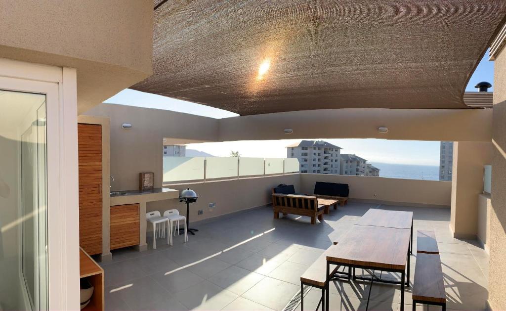 ein Wohnzimmer mit einem Tisch und einem Esszimmer in der Unterkunft Departamento con terraza propia incluida en azotea en Punta Puyai in Papudo