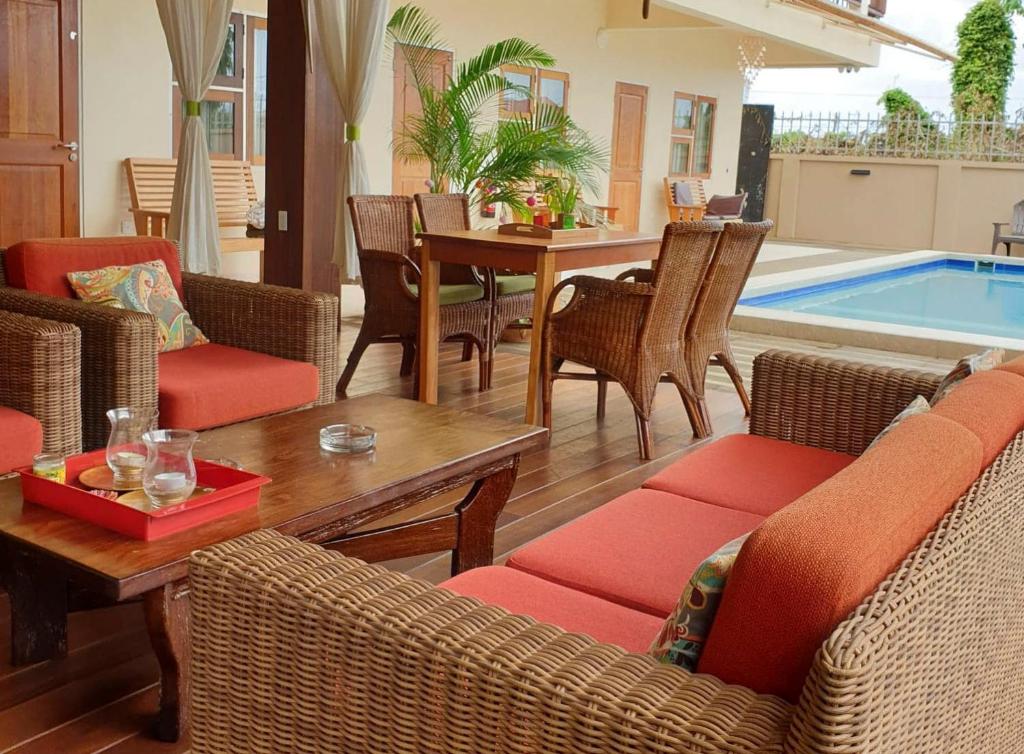 a living room with chairs and a table and a pool at Amalia Apartments in Paramaribo