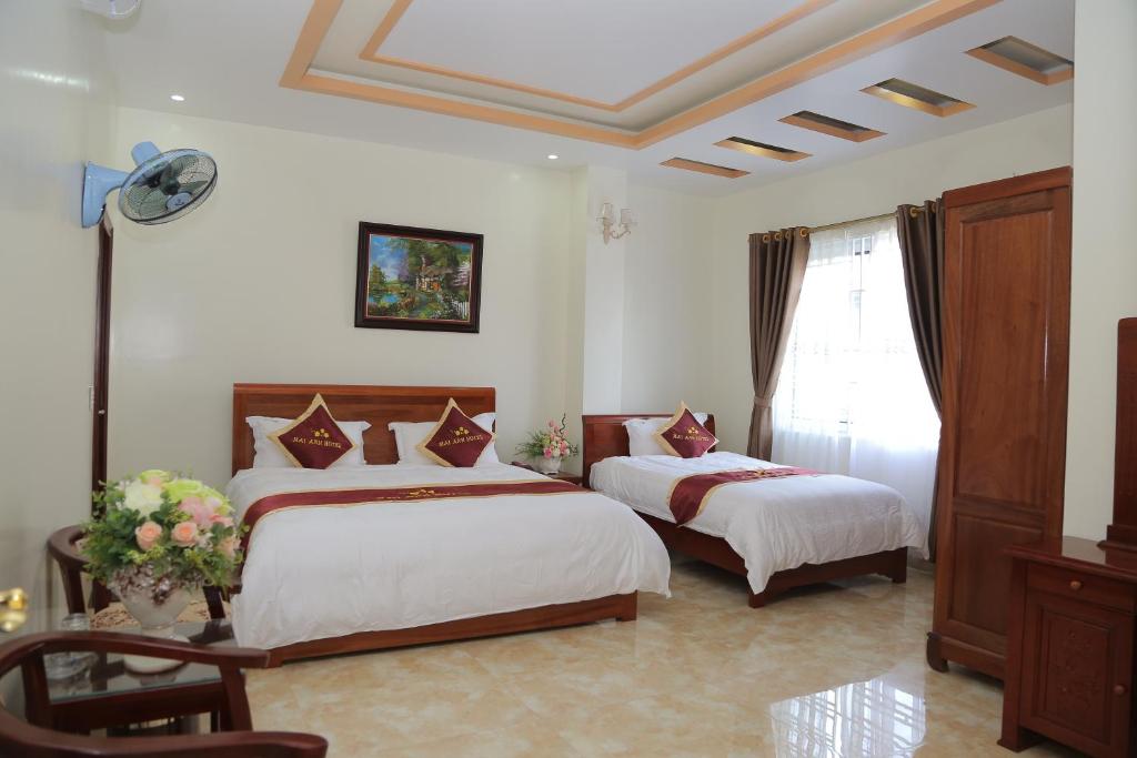 a hotel room with two beds and a window at Mai Anh Hotel in Lao Cai