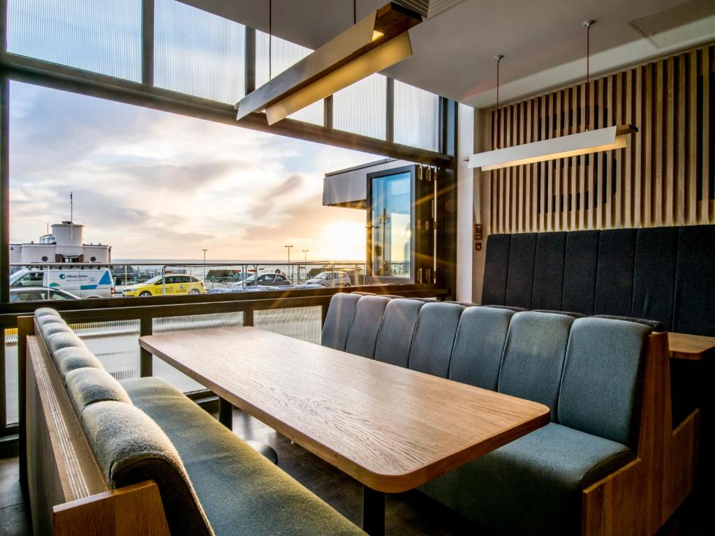 a dining room with a table and chairs and a window at Holiday Inn Brighton Seafront by IHG in Brighton & Hove
