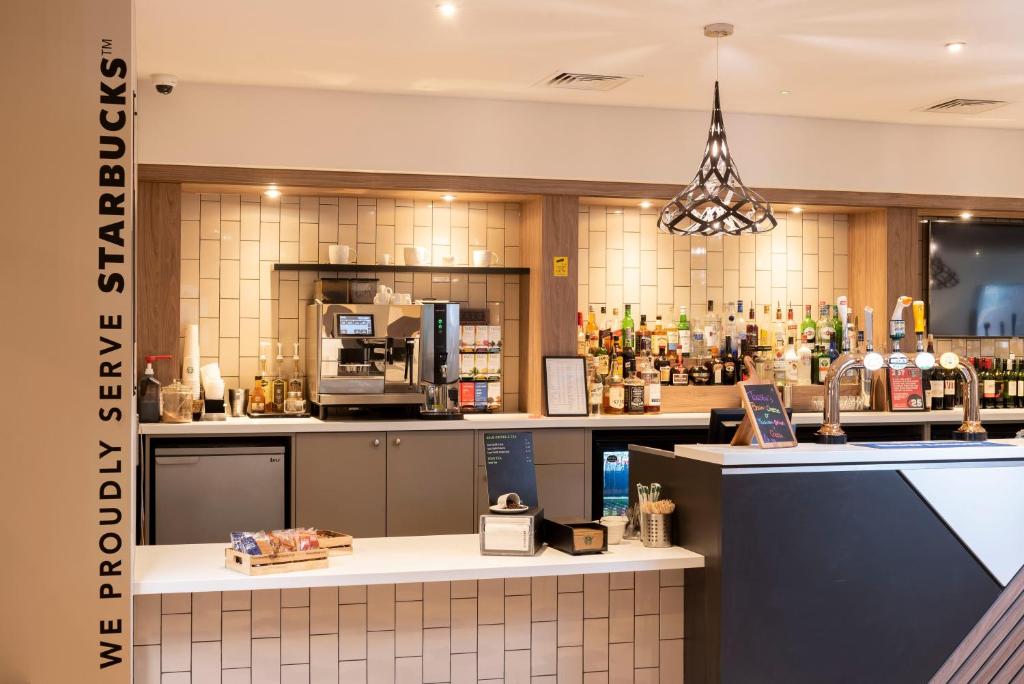 a coffee shop with a counter and a bar at Holiday Inn Birmingham M6, Jct7, an IHG Hotel in Birmingham