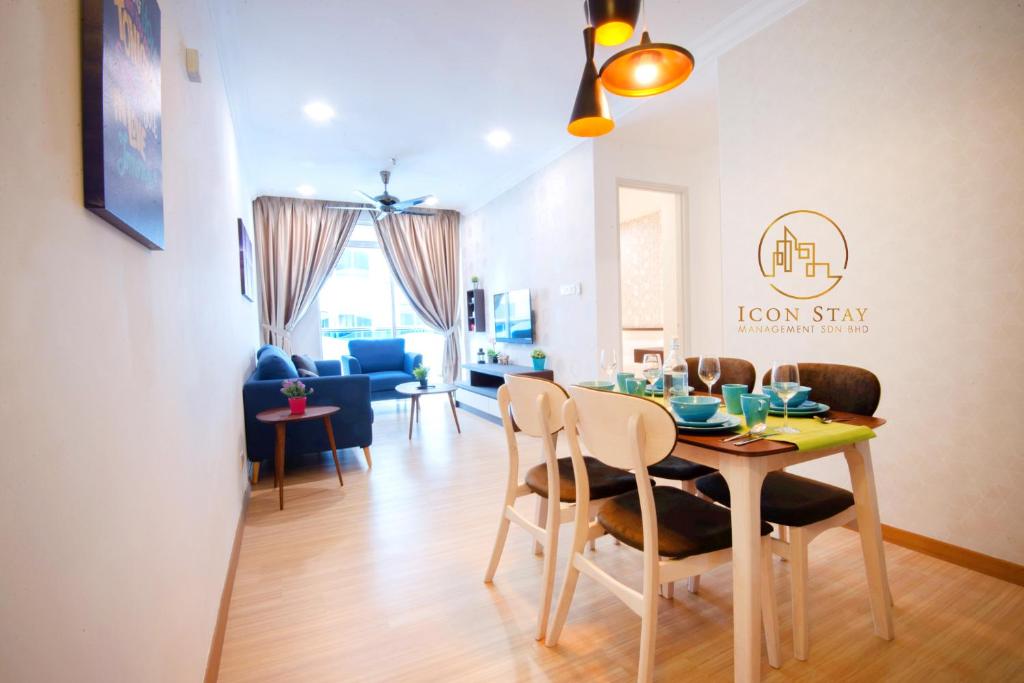 comedor y sala de estar con mesa y sillas en The Wave Residence Melaka, en Melaka