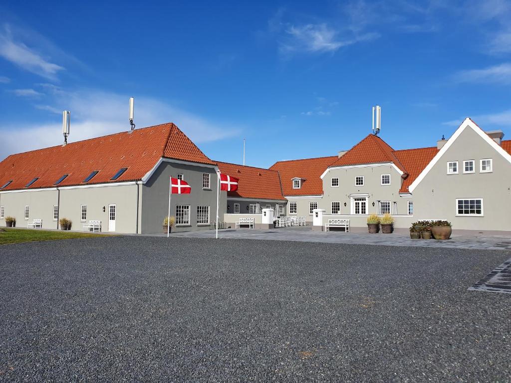 un grand bâtiment blanc avec des toits rouges dans l'établissement Hotel Nor - Badehotellet, à Fjerritslev