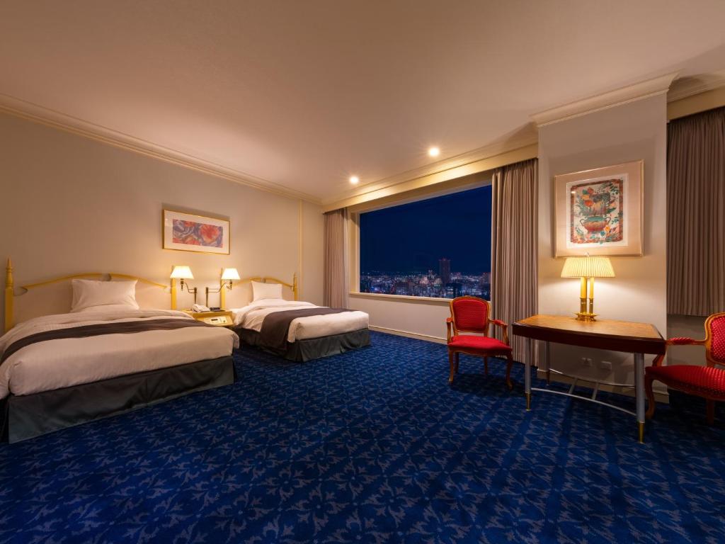 a hotel room with two beds and a window at Rihga Royal Hotel Hiroshima in Hiroshima