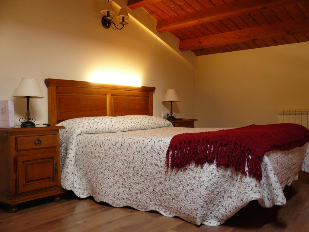 a bedroom with a bed and a wooden head board at Casa Rural El Rincón de Elena in San Esteban de Gormaz