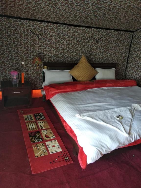 una camera da letto con un grande letto con un piumone rosso di Royal Riders Camp a Hundar