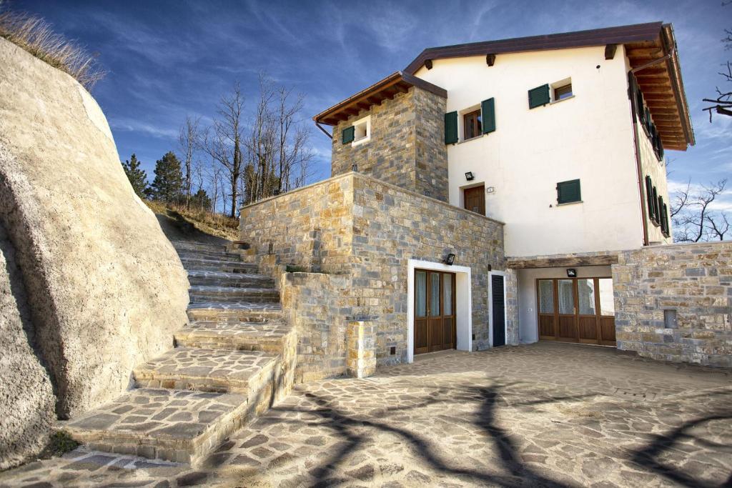 uma casa de pedra com escadas que levam até ela em Villa Viktoria & Andras em Tredozio