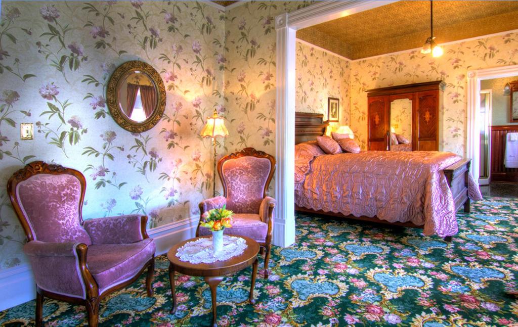 a bedroom with a bed and a table and chairs at Gingerbread Mansion in Ferndale
