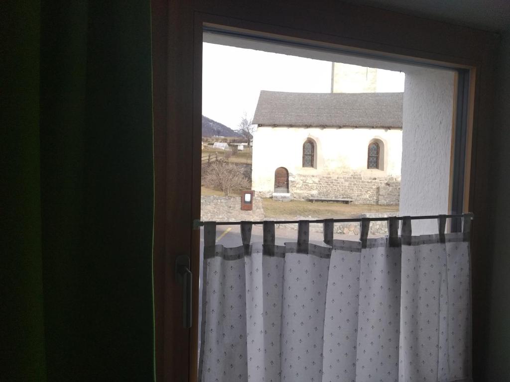 een open raam met uitzicht op een kerk bij Ora et labora in Malles Venosta