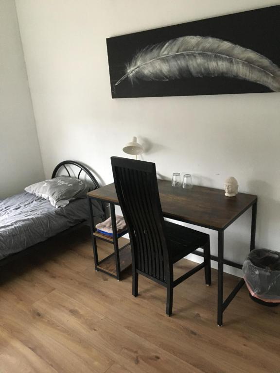 1 dormitorio con escritorio, 1 cama, mesa y silla en City Center Enschede Homestay en Enschede