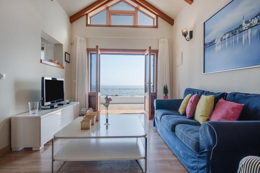 a living room with a blue couch and a tv at Casa Jimena in Punta de Mujeres