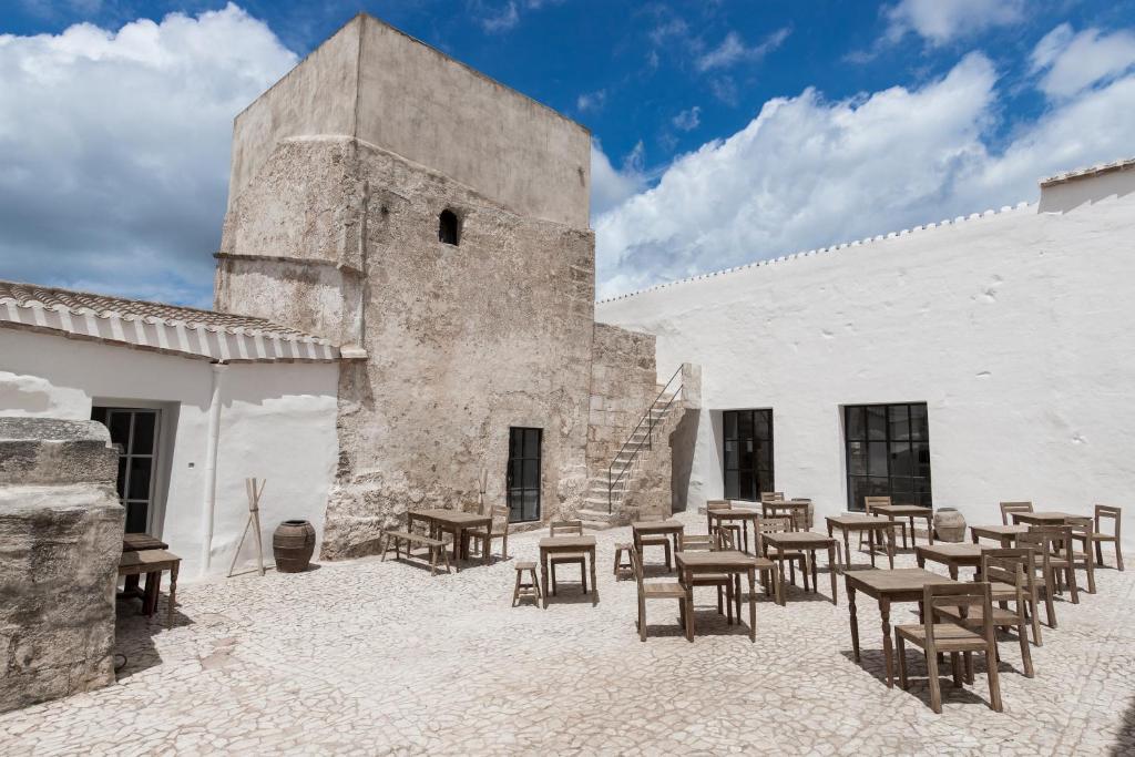 a group of tables and chairs outside of a building at Torre Vella Fontenille Menorca in Son Bou