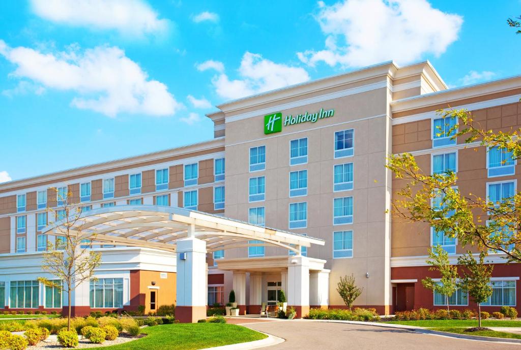 un edificio de hotel con un cartel en la parte delantera en Holiday Inn Battle Creek, an IHG Hotel, en Battle Creek