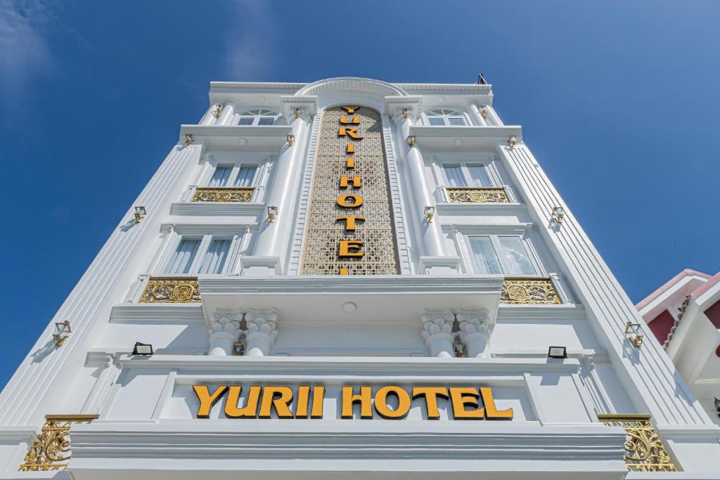 a tall white building with a yuval hotel sign on it at Yurii Hotel in Phan Thiet