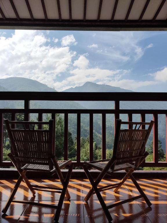 two chairs on a balcony with a view of the mountains at Kingtaiwan Hotel in Lugu Lake