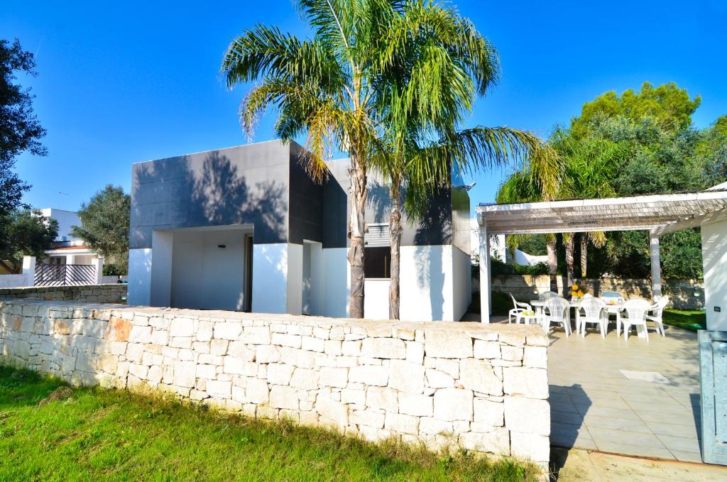 ein Haus mit einer Steinmauer und einer Palme in der Unterkunft Villa Giusi in Torre Colimena
